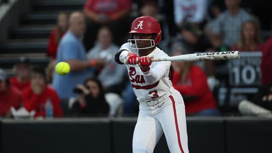 Alabama softball player Kristen White swings at the ball.