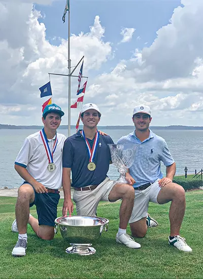 Jack Goldasich posing with teammates and trophies