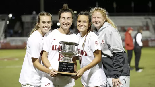 Felicia Knox, Kat Rogers, Riley Mattingly Parker and Gessica Skorka holding the SEC Championship trophy