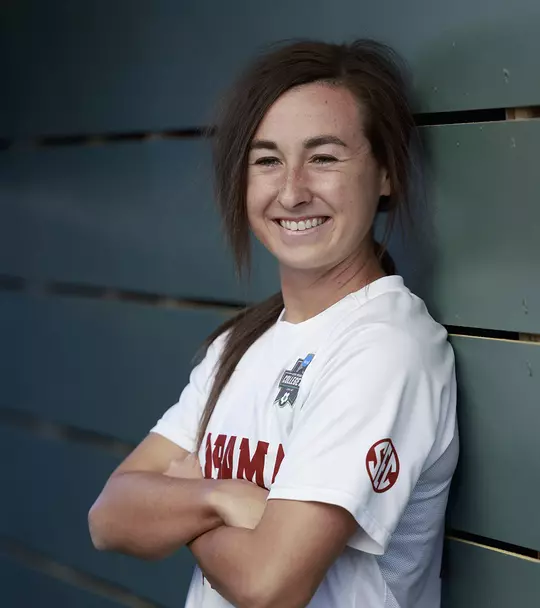 Kat Rogers leaning against a wall with her arms folded