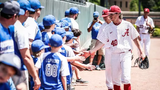 Brock Guffey giving five to a children's baseball team