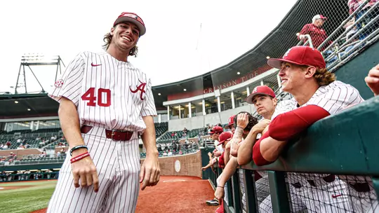 Brock Guffey standing next to the dugout at Sewell-Thomas Stadium