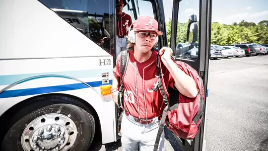 Brock Guffey carrying a backpack off the team bus