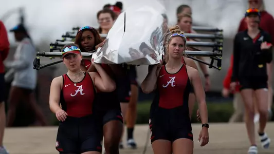 Alabama rowers walking a boat to the dock