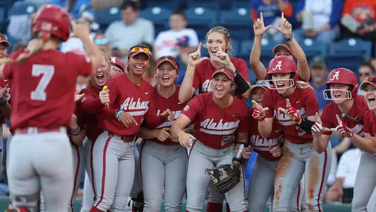 Softball team waiting at home to celebrate a Bailey Dowling home run