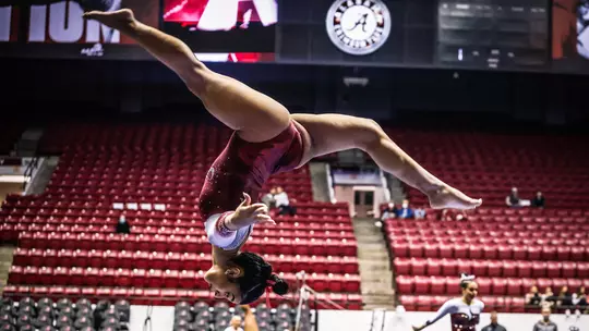 Luisa Blanco mid-flip on the balance beam