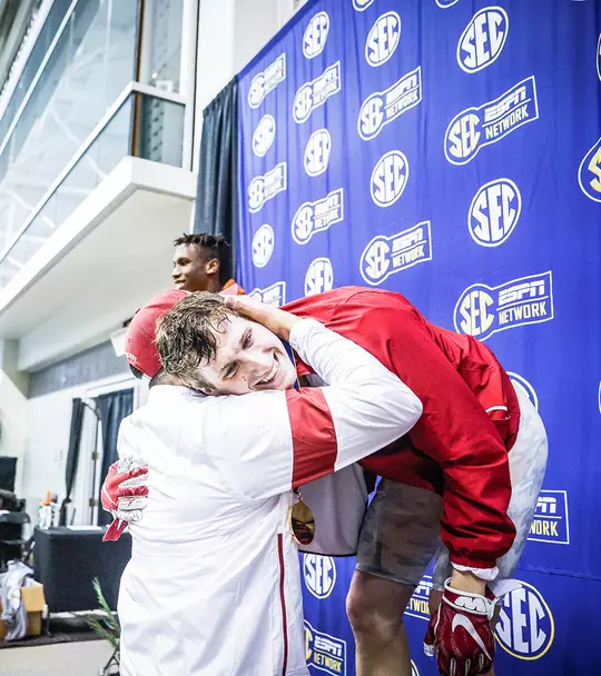 Ozzie Quevedo hugging Derek Maas after he medaled