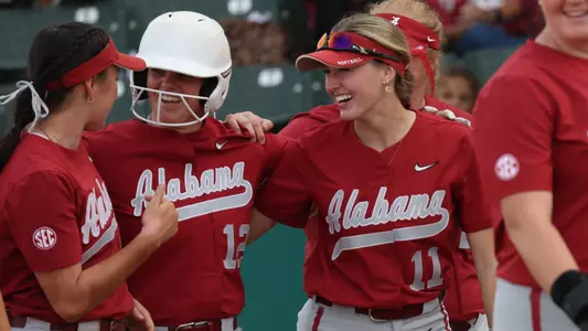 Kali Heivilin and Larissa Preuitt celebrate with Emma Broadfoot after she hit a home run vs. Chipola (Oct. 22, 2023)