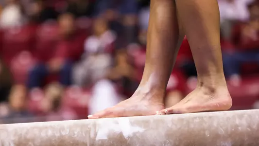 A student-athlete's feet while standing on the balance beam