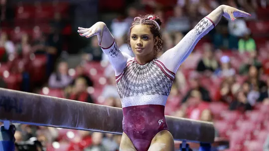 Makarri Doggette posing next to the balance beam