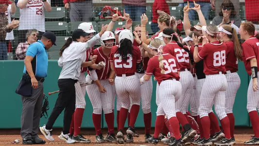 The team celebrates at home plate after a Faith Hensley home run (Feb. 25, 2023)