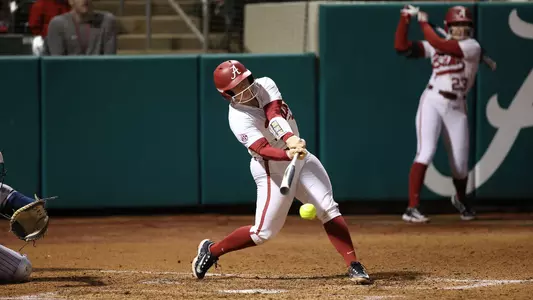 Alabama softball player Emma Broadfoot swings as the ball.