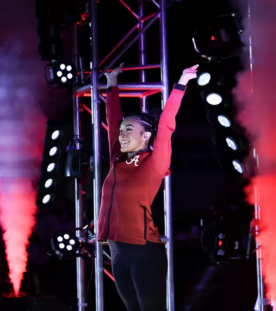 Luisa Blanco with her arms raised surrounded by smoke and red lights during her introduction