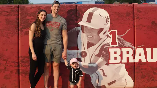 Assistant Coach Kayla Braud and her husband David and daughter Dylan pose at Rhoads Stadium