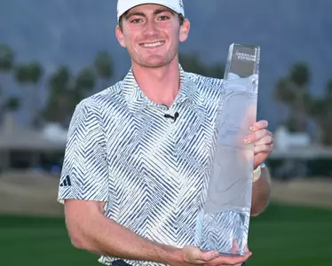 Nick Dunlap holding the American Express trophy won on the PGA Tour as an amateur