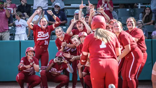 Alabama softball players wait at home plate following a home run from Catelyn Riley (7) vs. Itawamba (Oct. 13, 2024)