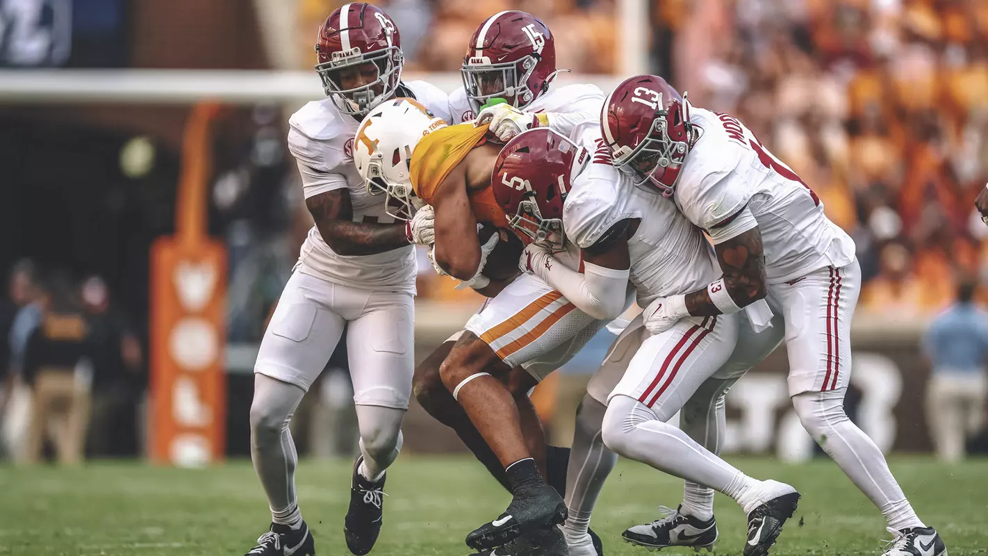 Alabama players tackling a Tennessee player carrying the ball
