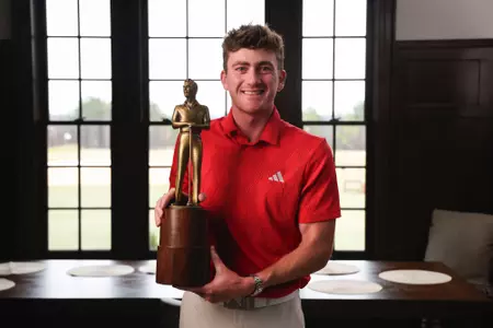 Nick Dunlap holding the Arnold Palmer Award for the PGA TOUR Rookie of the Year
