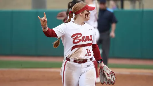 Alabama softball player Emma Broadfoot signals with her hands on the field.