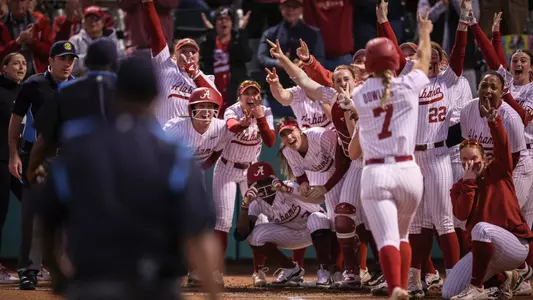 Alabama softball players await Bailey Dowling (7) at home plate after she hit a home run vs. Florida (March 11, 2024)