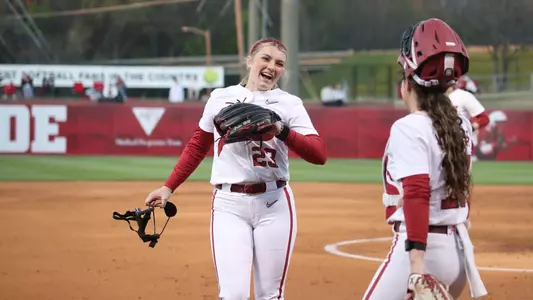 Alabama pitcher Jocelyn Briski (23) laughing with catcher Riley Valentine (17) on the field.