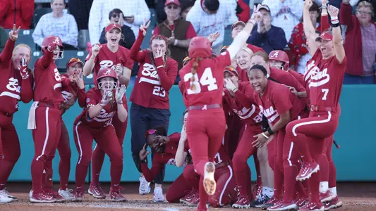 Marlie Giles (34) heads home as her teammates await celebrating a home run vs. Arizona (March 2, 2024)