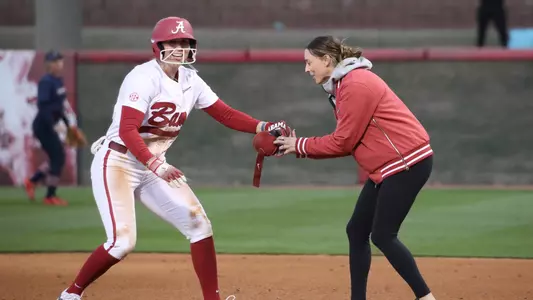 Alabama softball player Kendal Clark (15) celebrates her hit against Samford with Coach Kayla Braud.