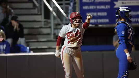 Alabama softball player Kali Heivilin (22) celebrates hitting a triple.