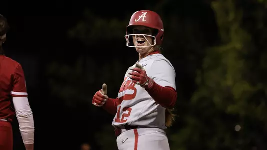 Alabama softball player Emma Broadfoot (12) smiling on the field.