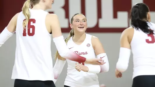 Alabama volleyball player Callie Kieffer smiling with teammates Kyla Dunaway and Allison Berent.