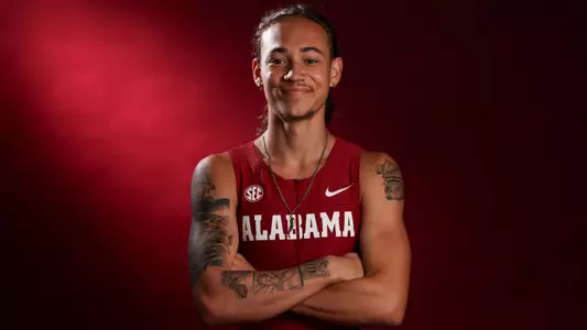Alabama Track and Field's Louis Martinez posing in front of crimson background