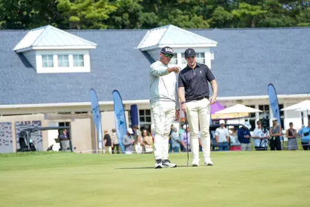 Dominic Clemson and assistant coach Forrest Schultz discuss a putt at the Folds of Honor Collegiate