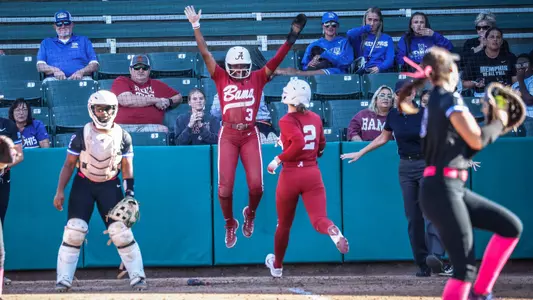 Kristen White (3) jumps and smiles at home plate awaiting Gerritt Griggs (2) who is running home
