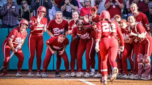 Alabama softball players wait at home plate to celebrate after Kali Heivilin (22) hit a home run vs. Oklahoma (April 13, 2025)
