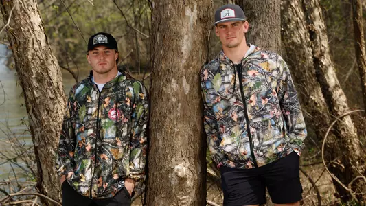 Two men wearing the camo pattern with Alabama logos