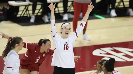 Maddie Snider cheering on the court alongside teammates while during a match against Lipscomb University.