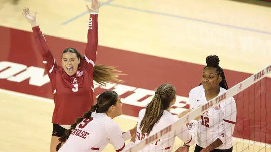 Trinity Stanger cheering on the court alongside teammates during match against UNC Asheville.