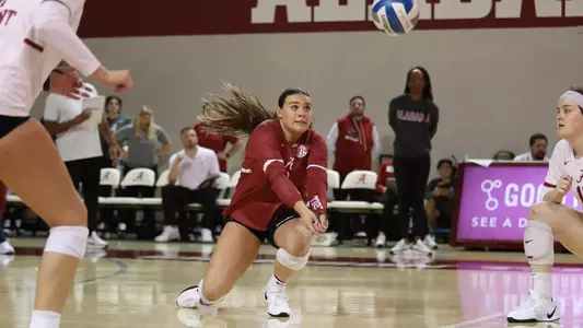 Trinity Stanger diving to dig ball in match against Wake Forest.