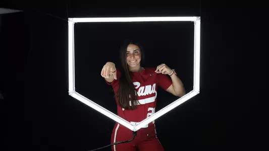 Ana Roman posing for media day in front of home plate lighting structure.