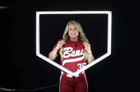 Ambrey Taylor posing for media day in front of home plate lighting structure.