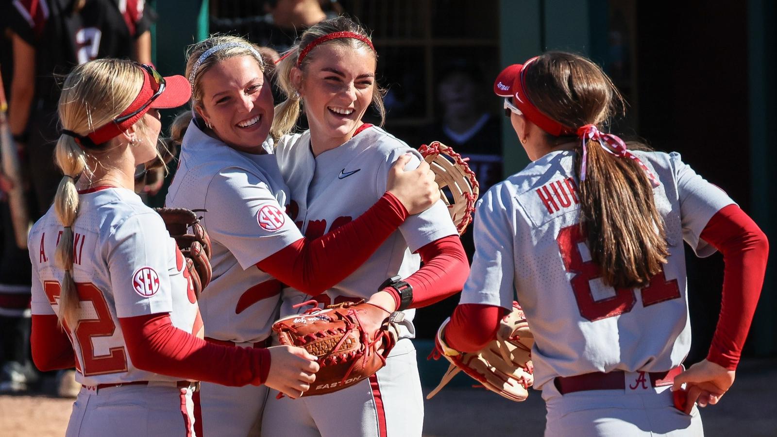 Alabama teammates hug Jocelyn Briski after her perfect game