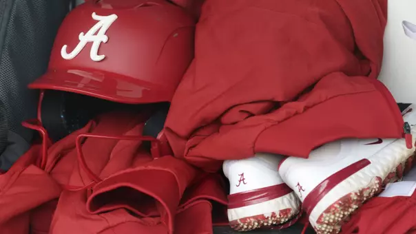 Detail photo of a helmet, jacket and cleats in the dugout pregame