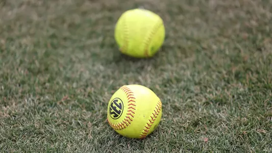 Two softballs in the grass