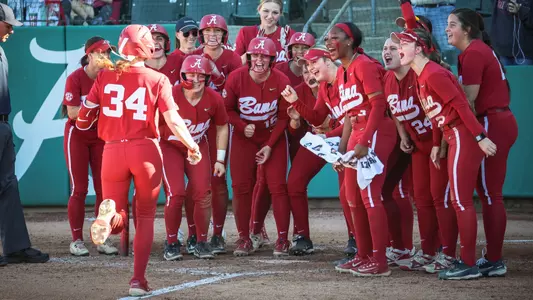 Alabama softball players cheer together at home plate after a Marlie Giles (34) grand slam vs. USF (Feb. 28, 2026)