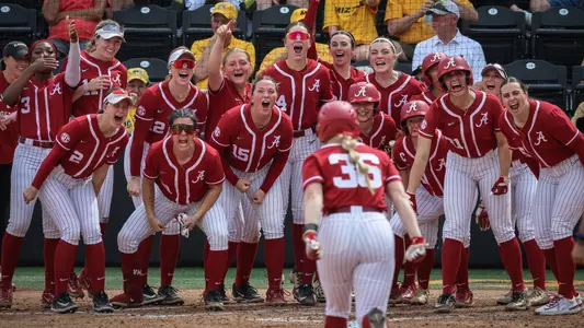 Alabama softball players wait at home plate to celebrate an Ambrey Taylor (36) home run