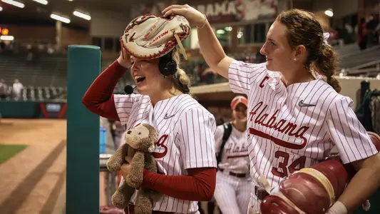 Marlie Giles (34) puts a glove on Brooke Wells' (15) head during a postgame interview