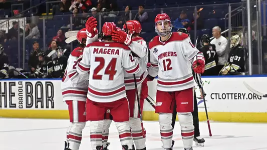 The Pioneers celebrate Austin Magera's third-period goal, which was his 100th career point.