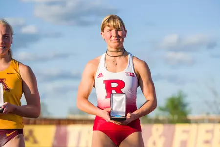 Chloe Timberg poses atop the podium after winning gold in pole vault