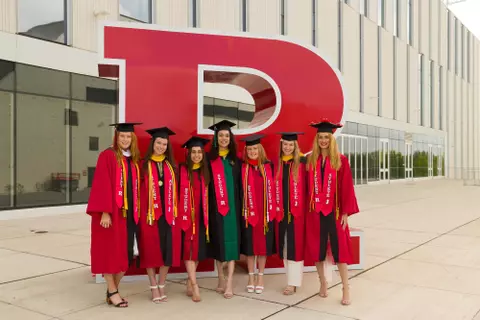 2022 Rutgers Swimming & Diving Graduates in front of the Block R at the APC