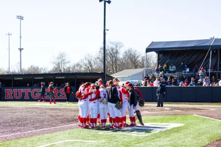 Rutgers softball huddles on the field during its Ohio State series at the RU Softball Complex